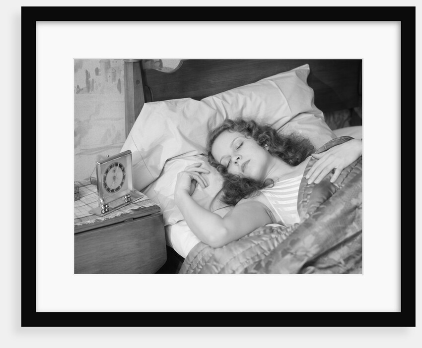 Woman sleeping asleep in bed alarm clock on night table by Anonymous