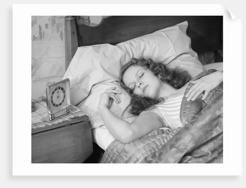 Woman sleeping asleep in bed alarm clock on night table by Anonymous