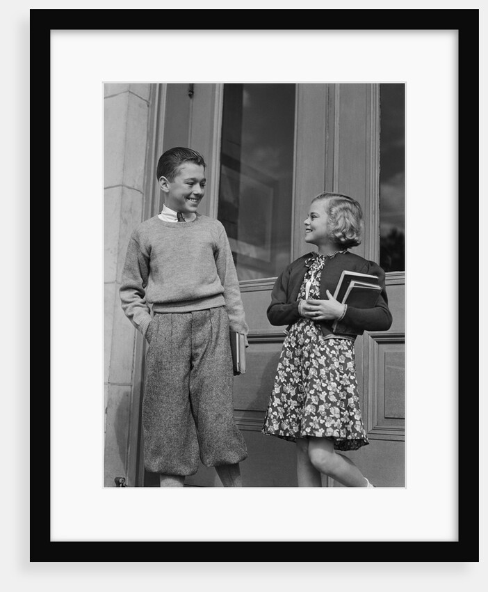 Smiling boy & girl holding school books by doors by Anonymous