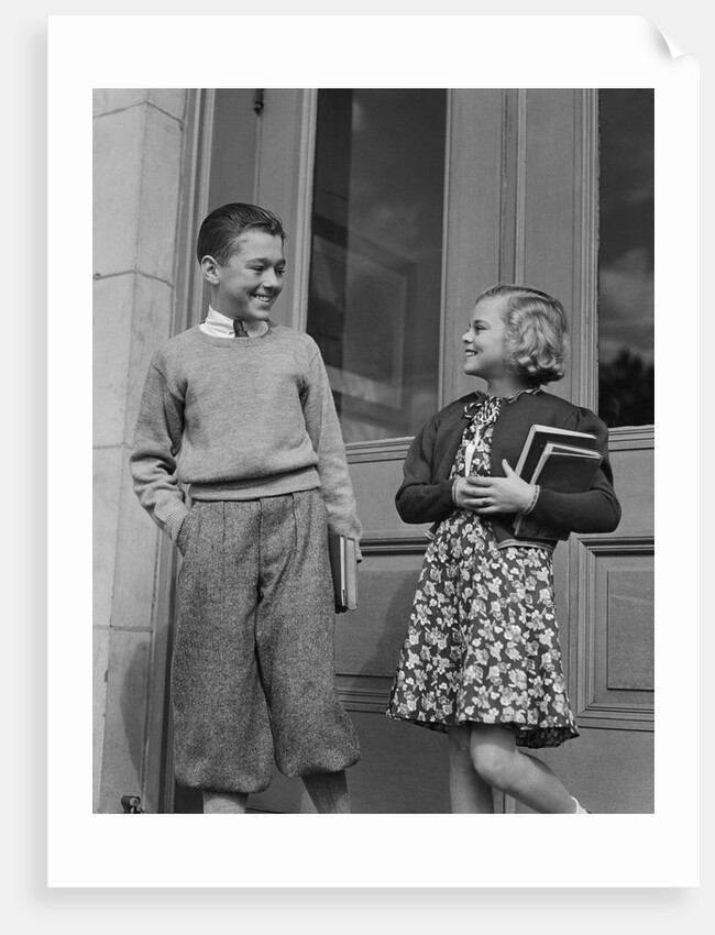 Smiling boy & girl holding school books by doors by Anonymous