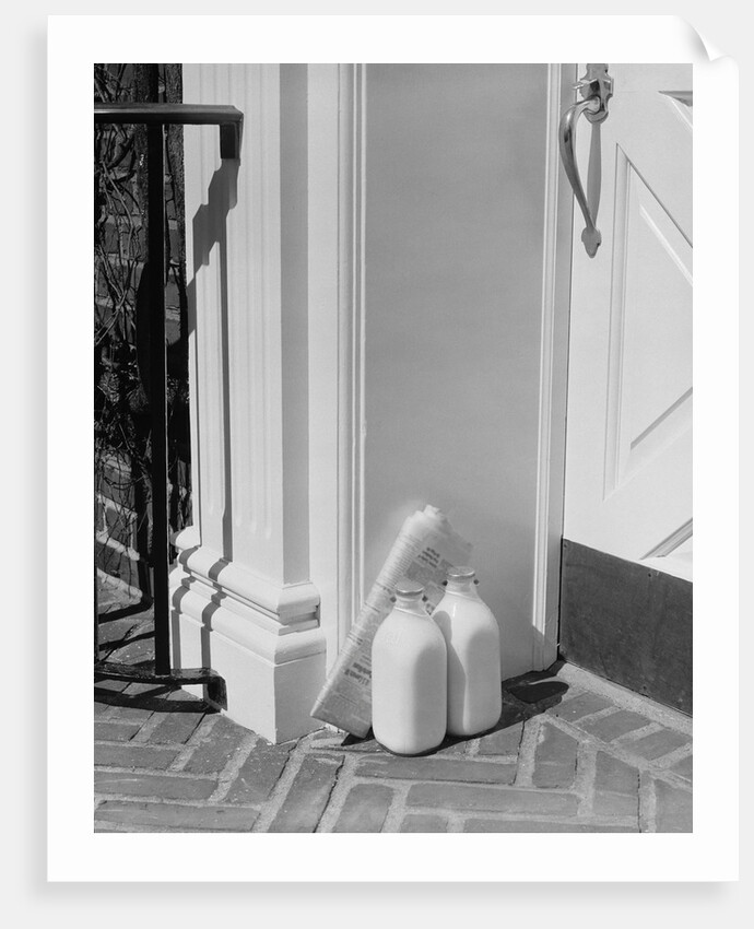 Glass milk bottles and newspaper by front door home delivery by Anonymous
