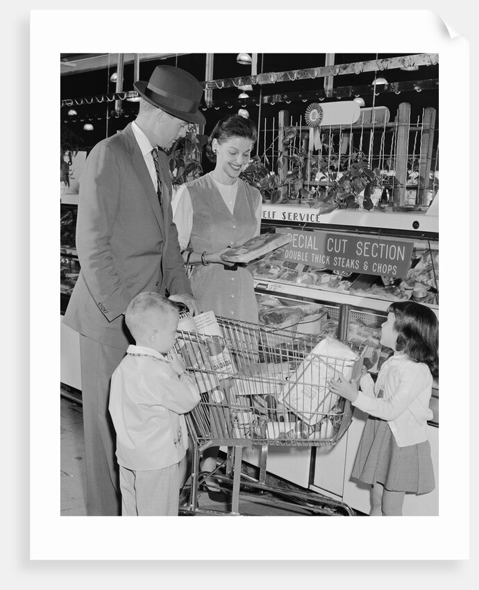 Family of 4 inside supermarket father pushing cart mother 2 kids by Anonymous