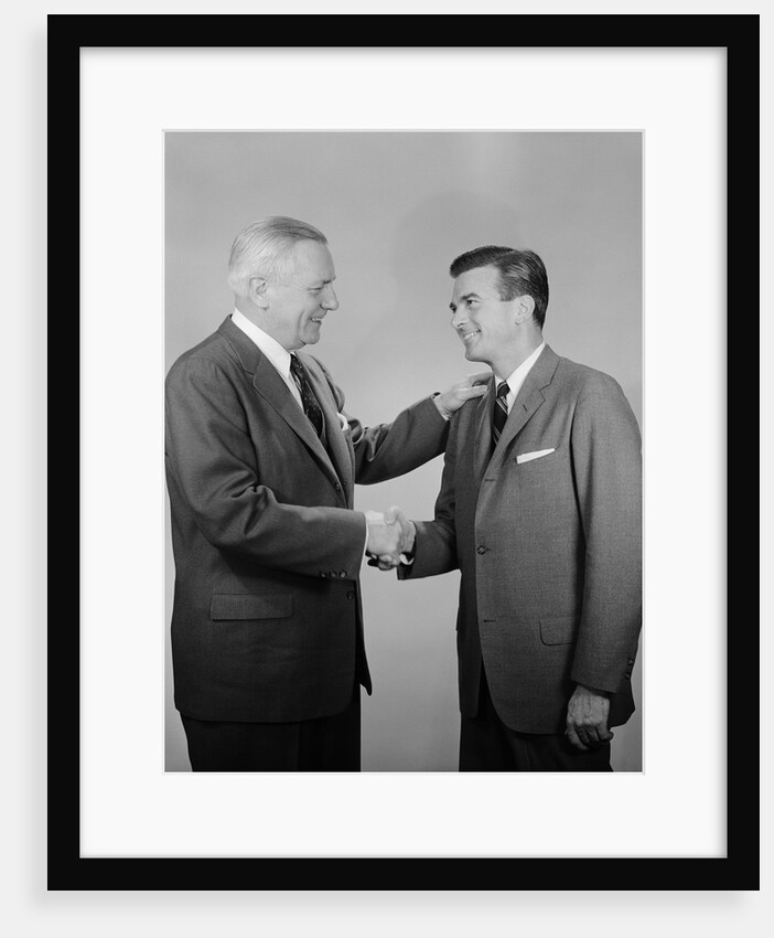Older and younger business men shaking hands by Anonymous