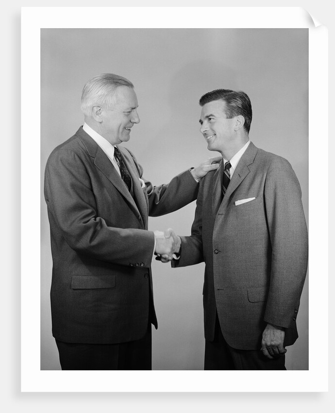 Older and younger business men shaking hands by Anonymous