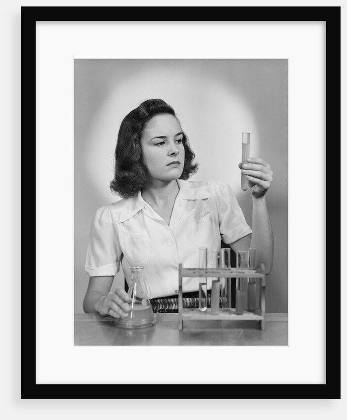 Young woman chemist holding up test tube by Anonymous