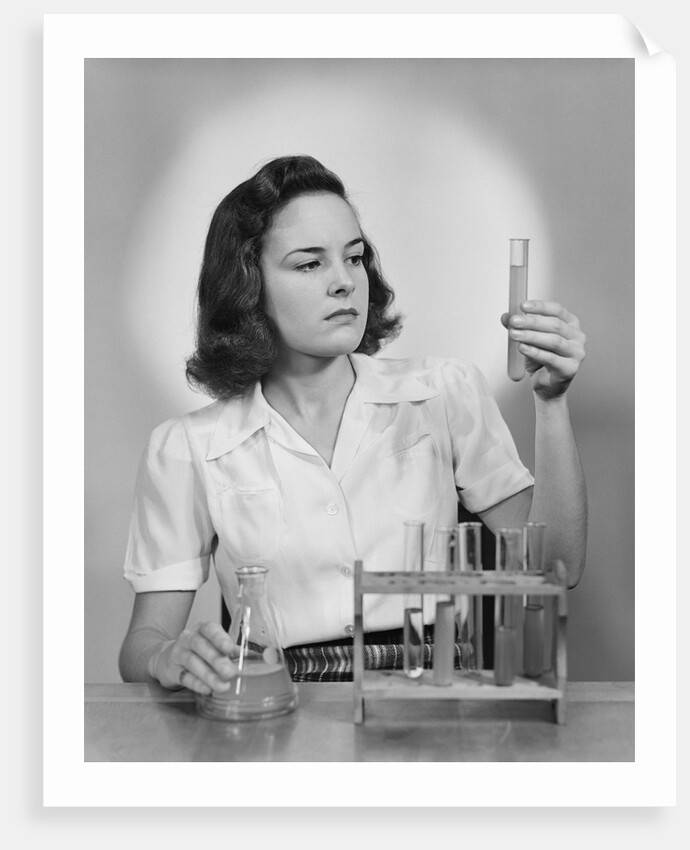 Young woman chemist holding up test tube by Anonymous