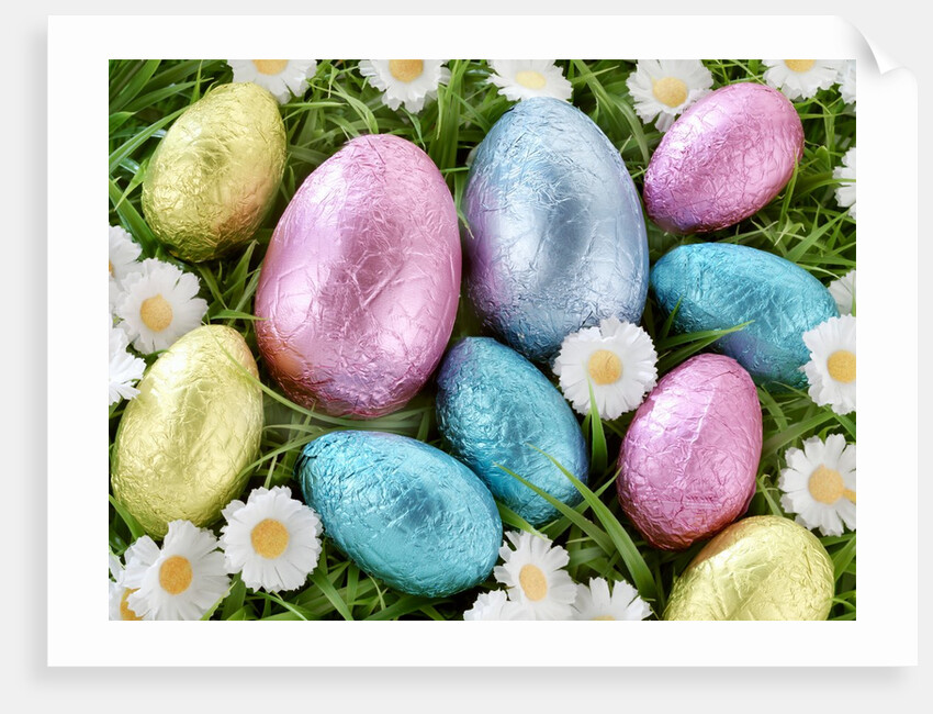 Chocolate Easter eggs in coloured foil in grass by Anonymous