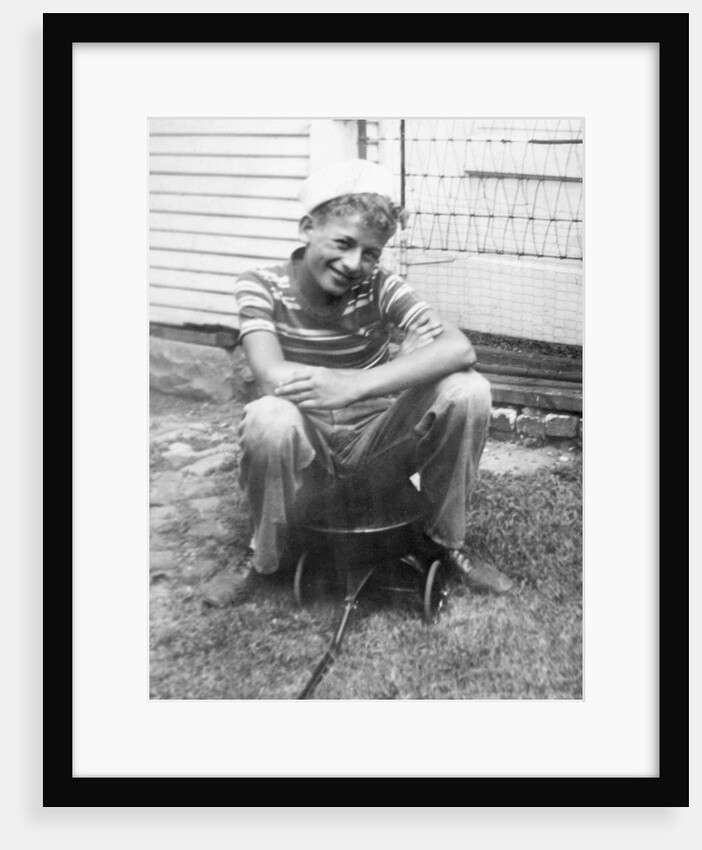 Boy sitting a very small wagon, ca. 1938 by Anonymous