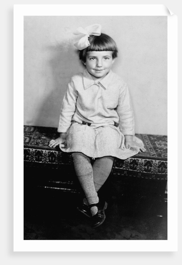 Young girl sits on a sofa, ca. 1933 by Anonymous