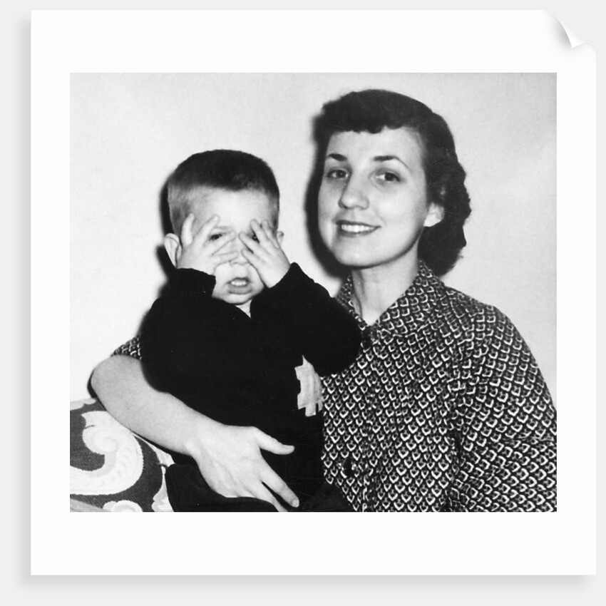 Mother holding son playing peek-a-boo, ca. 1955 by Anonymous