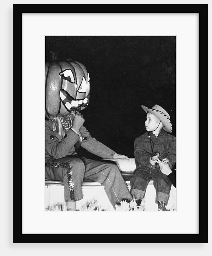 Young boy warily eyes pumpkin man, ca. 1955 by Anonymous