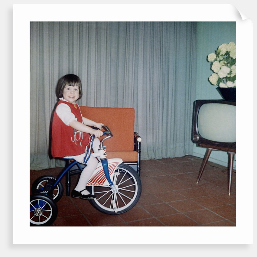 Young girl rides her new tricycle in the house, ca. 1967 by Anonymous