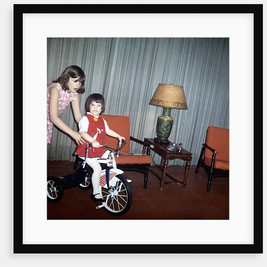 Older sister helps her sister with new bike, ca. 1967. by Anonymous