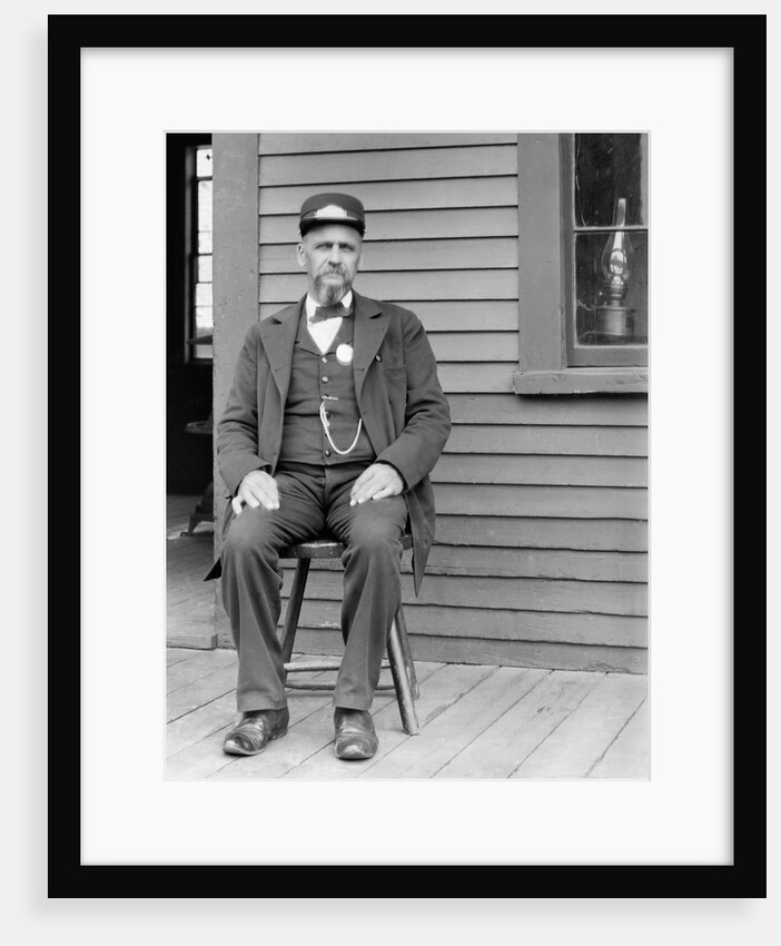 Station master sits at the train depot, ca. 1900. by Anonymous