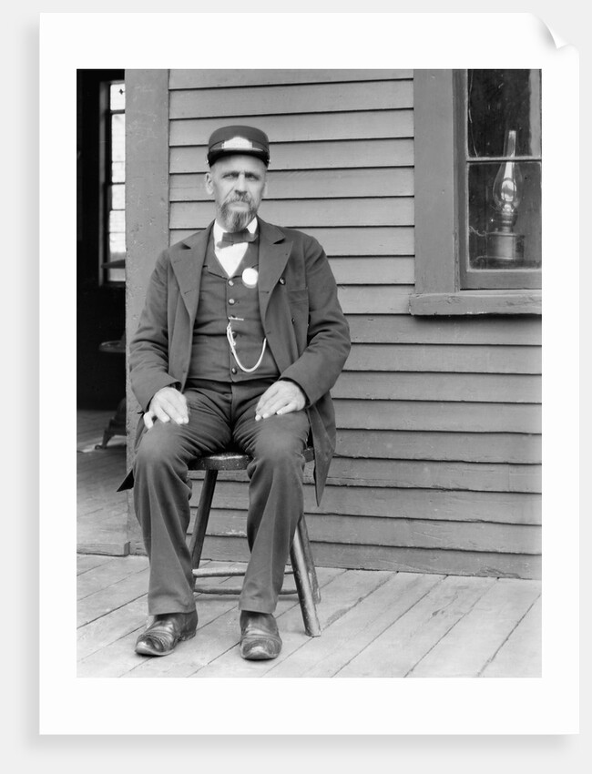 Station master sits at the train depot, ca. 1900. by Anonymous