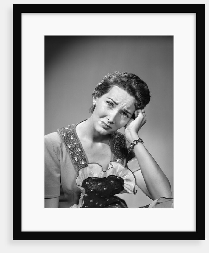 1950s housewife woman in print apron hand up to temple headache pain sad depressed facial expression worried serious looking at camera by Anonymous