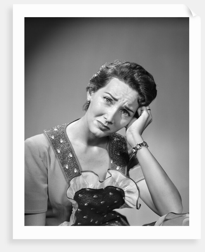 1950s housewife woman in print apron hand up to temple headache pain sad depressed facial expression worried serious looking at camera by Anonymous