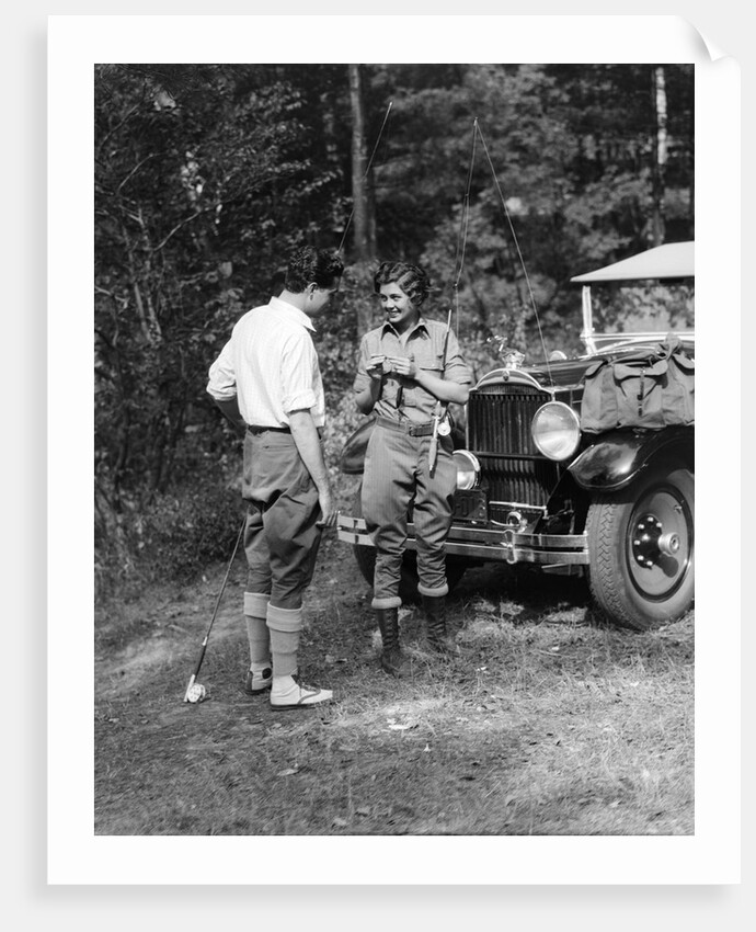 1920s 1930s couple man woman in fishing gear holding poles standing in front of packard touring automobile by Anonymous