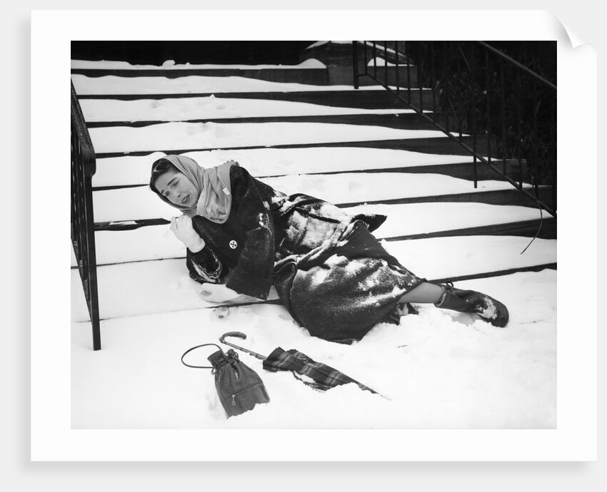 1950s woman lying on snow covered steps fall accident slip expression of pain by Anonymous