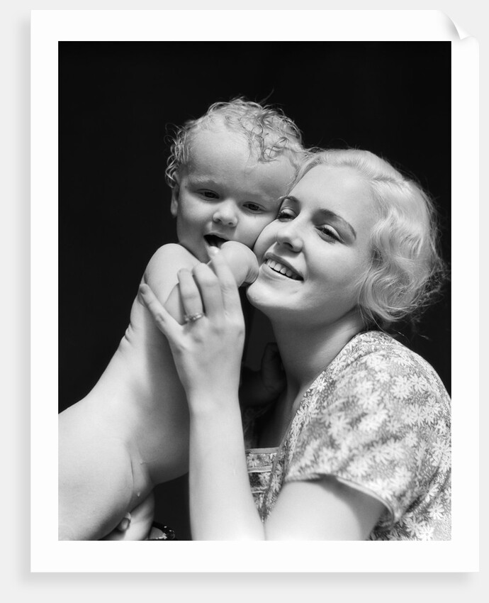 1930s blonde woman mother smiling holding baby to cheek by Anonymous