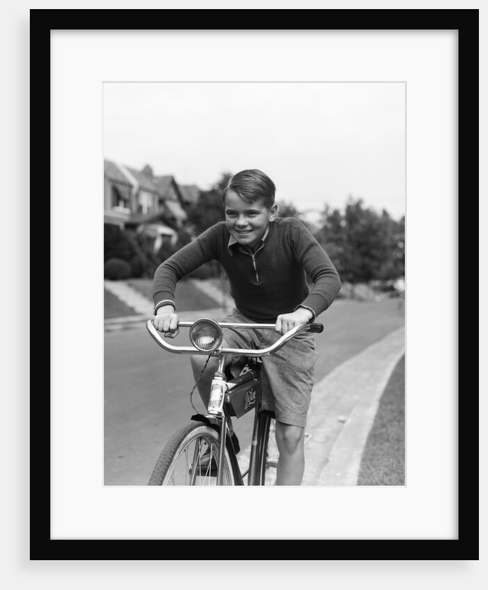 1930s smiling boy riding bicycle by Anonymous