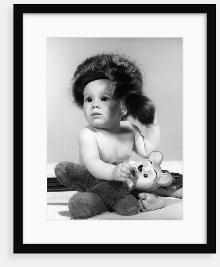1960s baby wearing coonskin hat by Anonymous