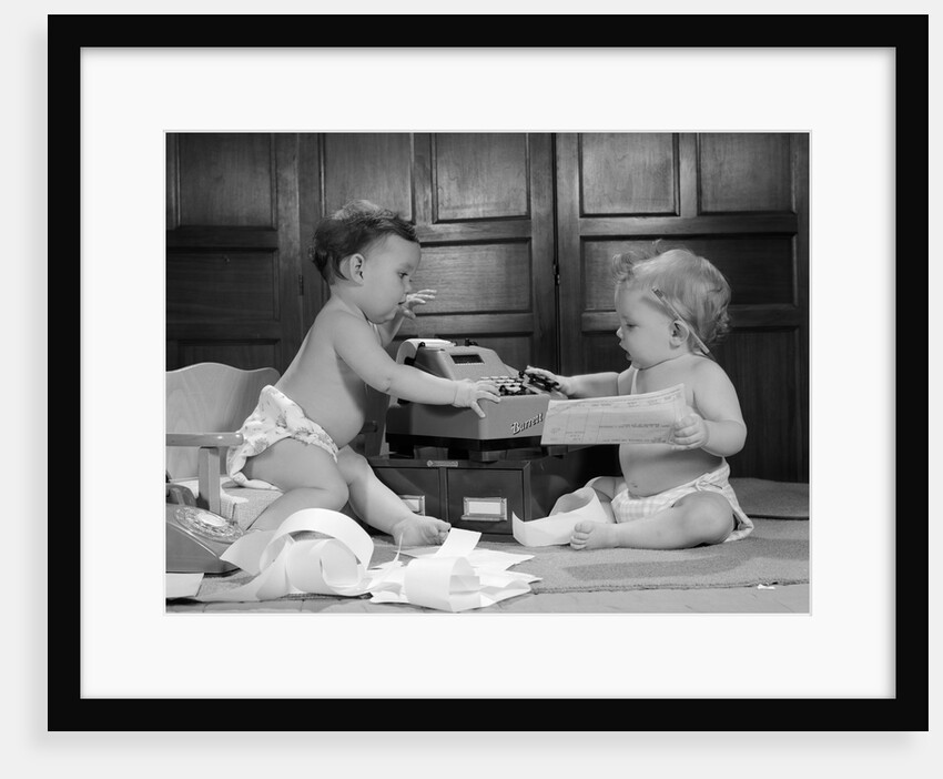 1960s two babies wearing diapers in business office with adding machine playing accountant by Anonymous