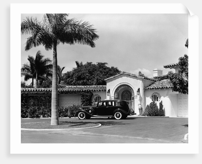 1930s car in circular driveway of tropical stucco spanish style home in sunset islands miami beach florida usa by Anonymous