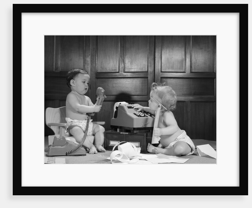 1960s 2 babies in diapers one on chair with telephone other on floor with adding machine pencil behind ear by Anonymous