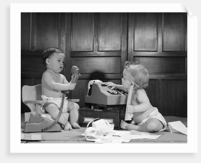 1960s 2 babies in diapers one on chair with telephone other on floor with adding machine pencil behind ear by Anonymous