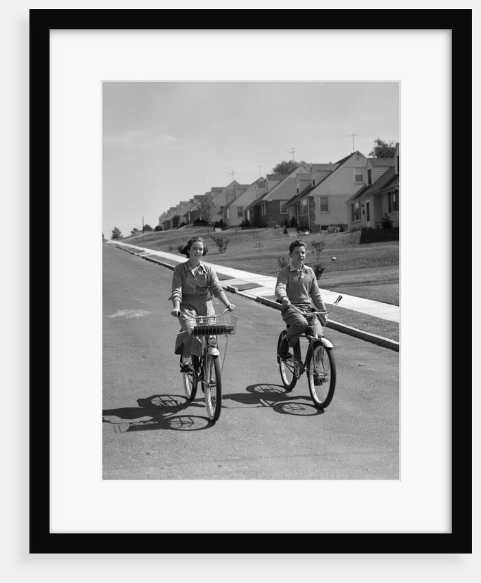 1950s teen boy girl riding bikes suburban neighborhood street by Anonymous