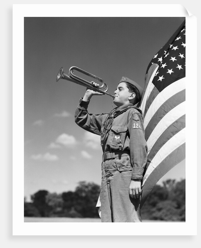 1950s profile of boy scout in uniform standing in front of 48 star american flag blowing bugle by Anonymous
