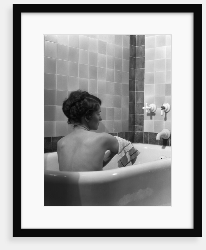 1920s 1930s young brunette woman sitting in luxury bathtub taking a bath by Anonymous