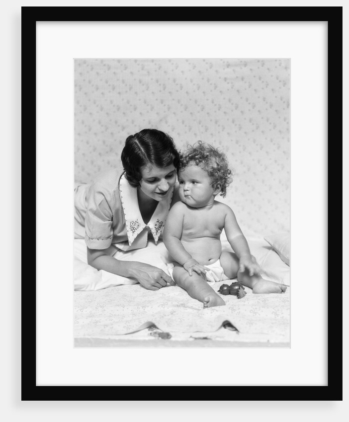 1920s 1930s woman mother lying sitting with baby on blanket by Anonymous