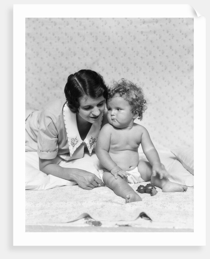 1920s 1930s woman mother lying sitting with baby on blanket by Anonymous