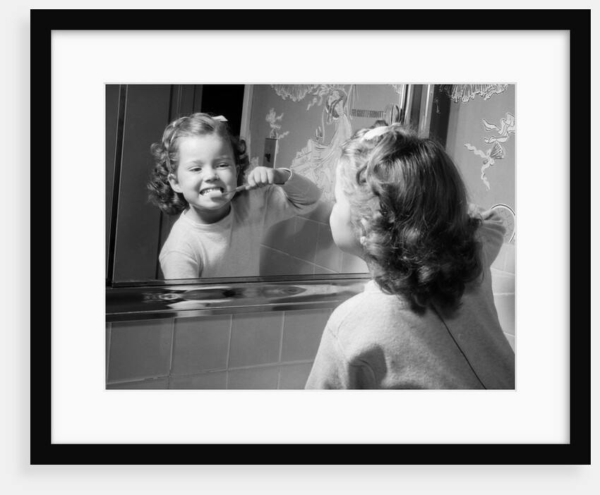 1950s girl looking in bathroom mirror brushing teeth by Anonymous