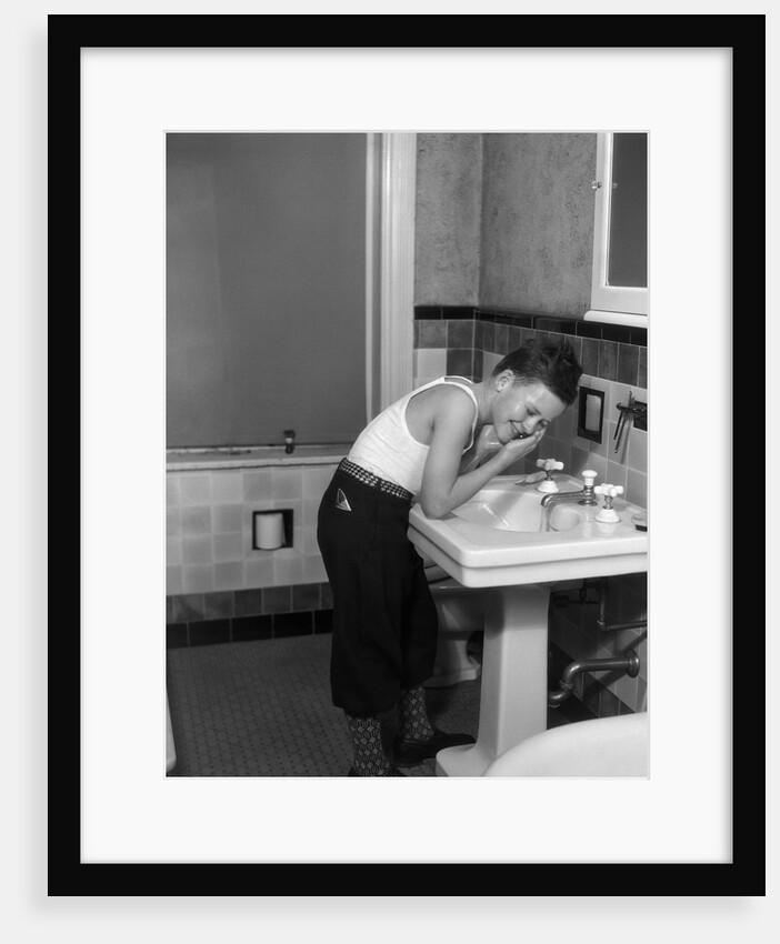 1930s boy washing face at bathroom sink by Anonymous