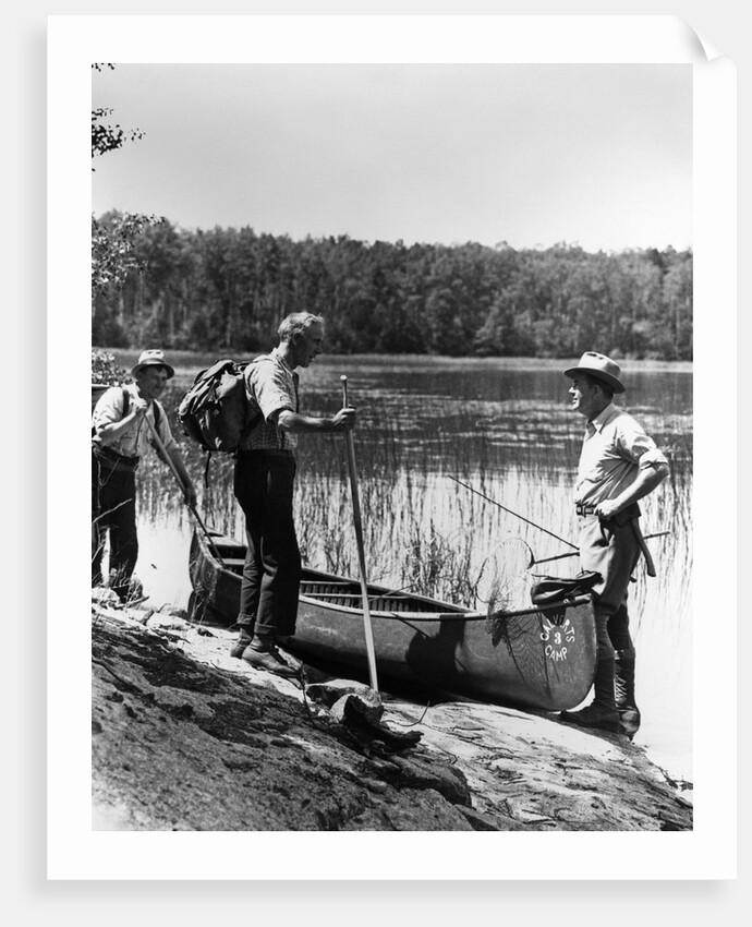 1930s three fishermen standing beside canoe holding fishing gear net backpack lake of the woods ontario by Anonymous