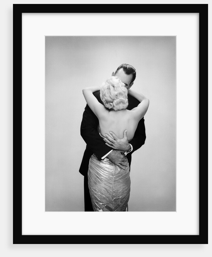 1950s 1960s kissing couple blond woman backless satin evening dress man embracing from behind by Anonymous