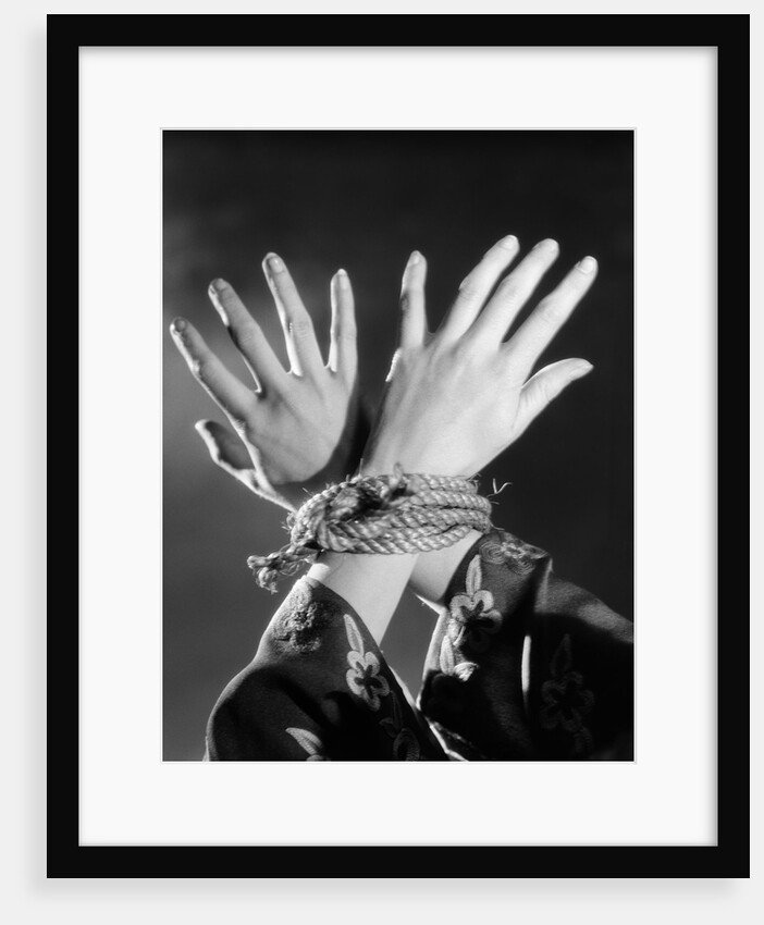 1930s woman's hands tied together by rope overhead view by Anonymous
