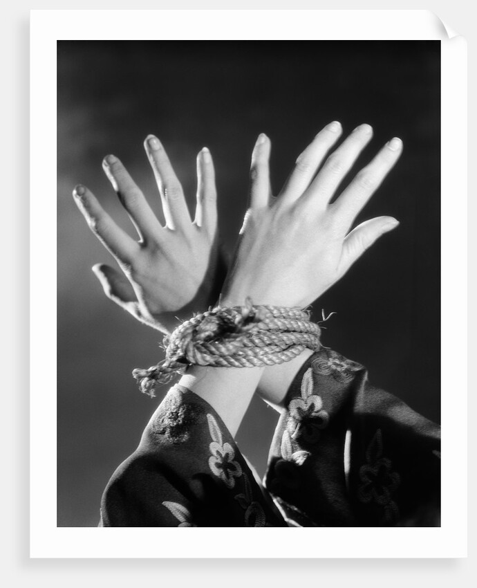 1930s woman's hands tied together by rope overhead view by Anonymous