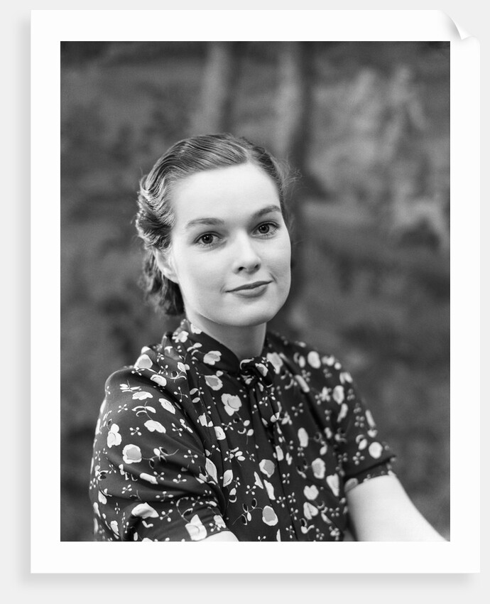 1930s portrait of brunette woman wearing printed blouse half smile mona lisa like beautiful eyes looking at camera by Anonymous