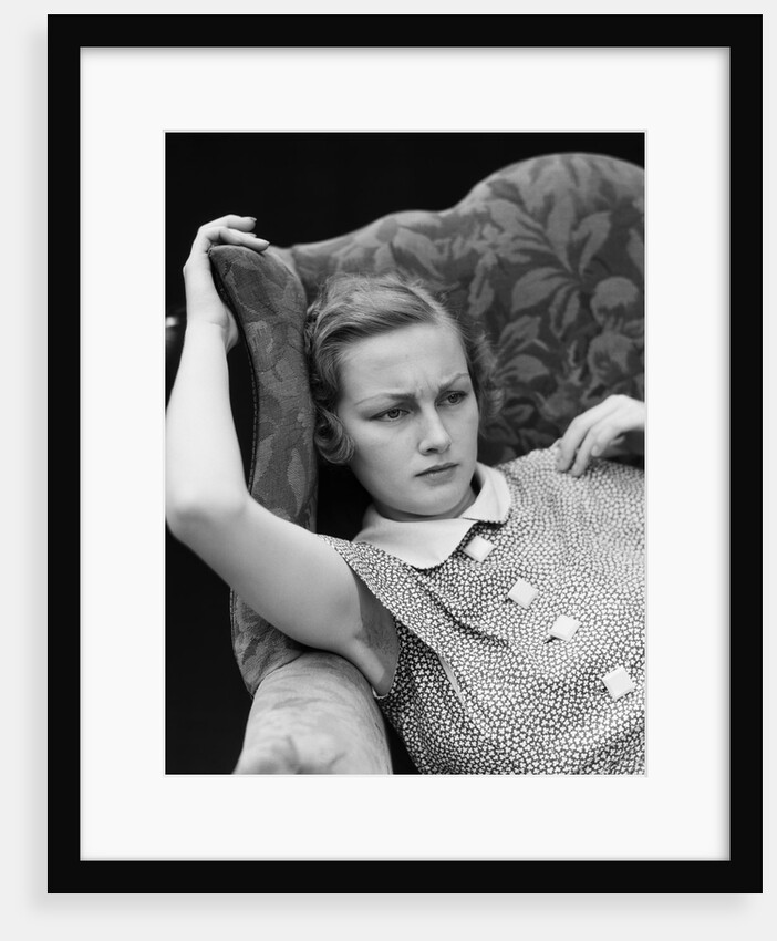 1930s woman sitting slumped position with a worried expression and a furrowed brow by Anonymous