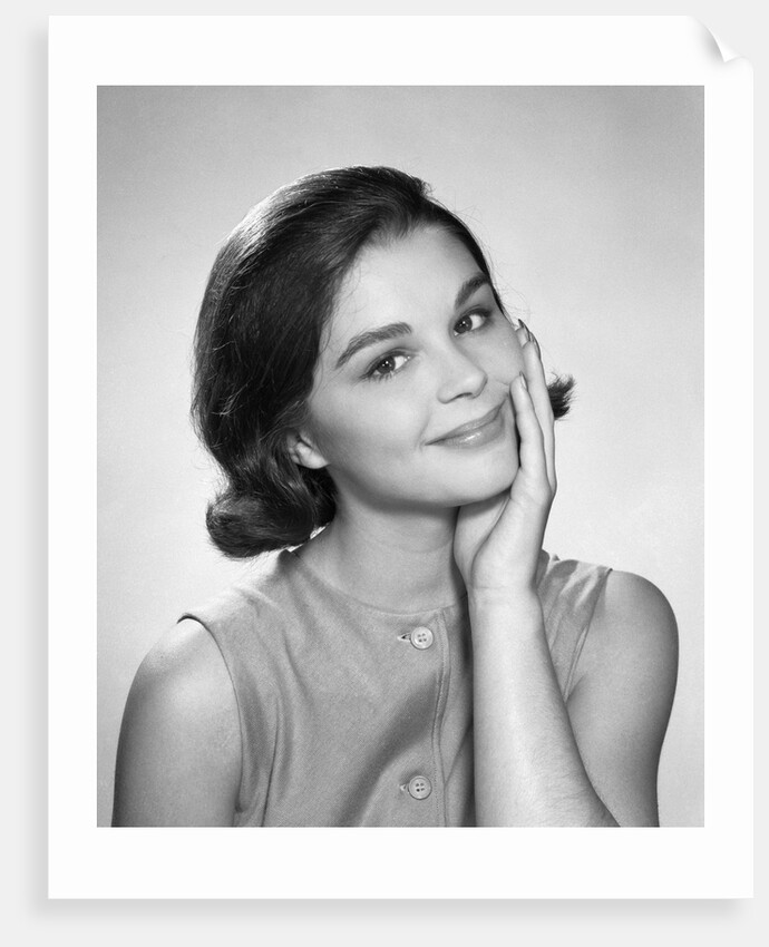 1960s smiling brunette young woman hand to cheek facial expression gesture looking at camera by Anonymous