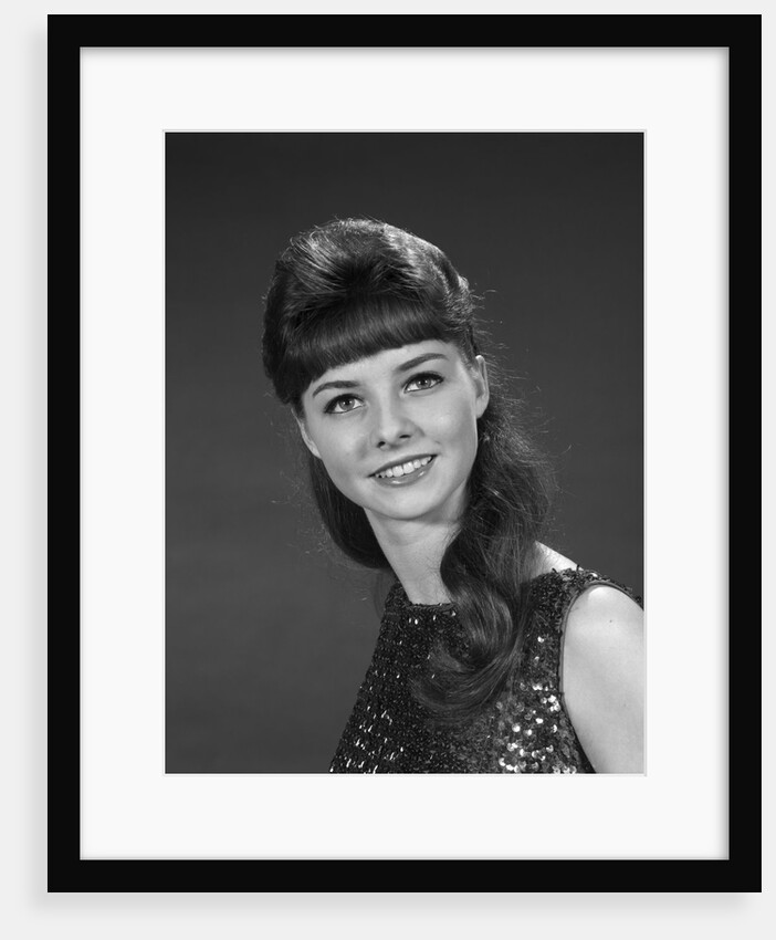 1960s portrait of smiling young woman in sequin dress looking at camera by Anonymous