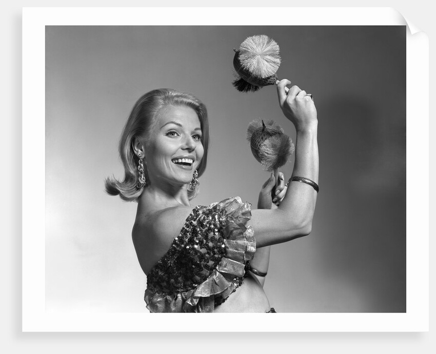 1960s smiling blond woman looking at camera shaking noise makers in her hands wear ruffled halter top by Anonymous
