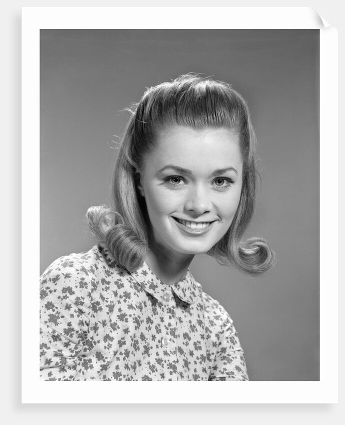 1960s portrait smiling woman wearing print blouse with flip hairdo by Anonymous