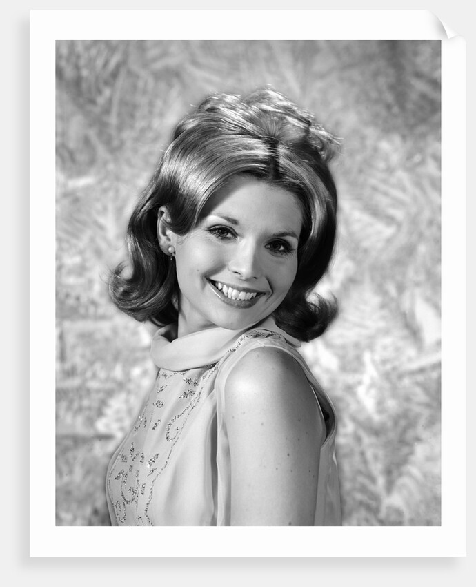 1960s portrait smiling blond woman looking at camera over shoulder by Anonymous