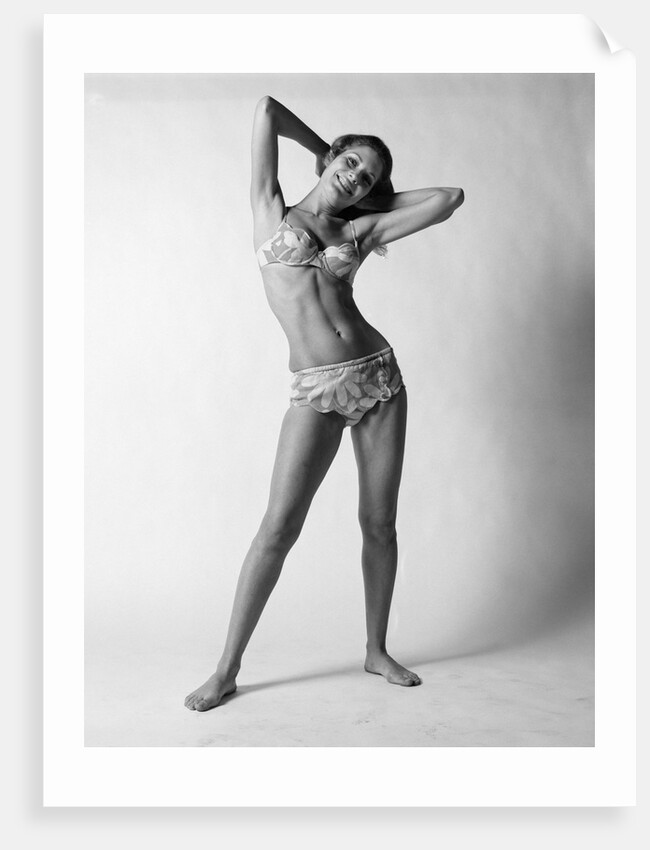 1970s smiling slender young woman standing posing wearing two piece bathing suit looking at camera by Anonymous