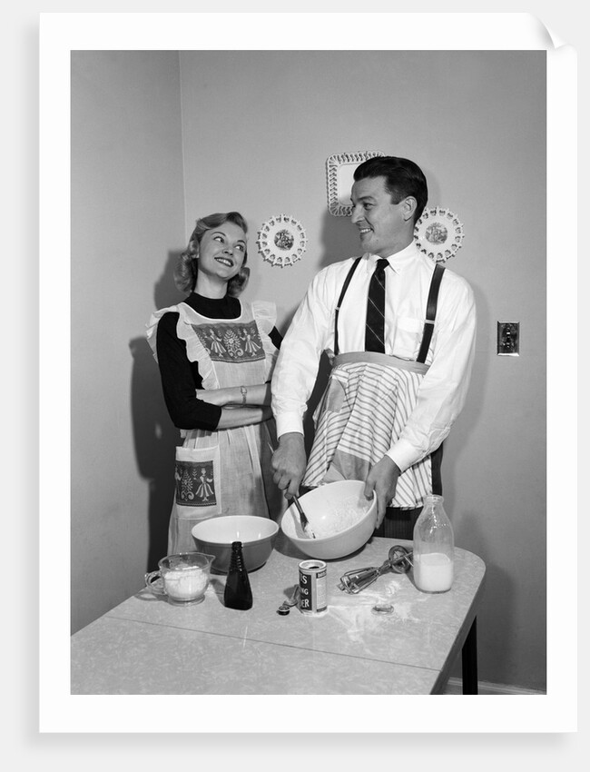 1950s satisfied amused smiling couple husband wife in kitchen cooking together by Anonymous